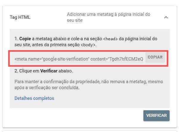 Captura de tela da interface do Google Search Console em português, mostrando as instruções para verificar a propriedade de um site por meio de uma metatag HTML. A página exibe um trecho de código <meta name="google-site-verification" content="Tgdh7hfECM2eQ">, que deve ser copiado e inserido na seção <head> da página inicial do site. Ao lado da metatag, há um botão com o texto "COPIAR" para facilitar a ação. Abaixo, há uma orientação para clicar no botão "VERIFICAR" após adicionar a tag, e uma observação importante alertando para não remover a metatag após a verificação, a fim de manter a confirmação da propriedade. Também há um link com o texto "Detalhes completos" para acessar informações adicionais sobre o processo.