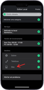 Captura de tela da interface de edição de local em um aplicativo móvel exibido em português, com o título "Editar Local" no topo. A tela apresenta a seção "Pontos obtidos" com um ícone de confirmação verde, seguida pela opção "Adicionar uma categoria". Em "Serviços", estão listados "Retirada no local" e "Banheiros...". A seção "Horário de funcionamento" exibe os períodos "Sun-Thu: 08:00 - 17:00" e "Fri: 08:00 - 12:00". Em "Detalhes", há ícones para "Sobre", "Telefone" e "Site", sendo este último destacado por uma seta vermelha. Ao final da tela, aparece a opção "Alertar um problema", indicando possibilidade de reportar inconsistências. A imagem representa o processo de personalização de informações comerciais em uma plataforma de mapeamento ou perfil empresarial.