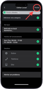 Captura de tela da interface de edição de local em um aplicativo móvel exibido em português, com o título "Editar Local" no topo. A tela apresenta diversas seções organizadas: "Pontos coletados" com um ícone de confirmação verde; "Adicionar uma categoria"; "Serviços", com "Retirada no local" e "Banheiros", ambos marcados com check verde; "Horário de funcionamento", exibindo "Sun-Thu 08:00 - 17:00" e "Fri 08:00 - 15:00", também confirmados com ícones verdes; e "Detalhes", com os campos "Sobre", "Telefone" e "Site", todos validados. Ao final da tela, há a opção "Alertar um problema". No canto superior direito, um botão "Pronto" está destacado por uma seta vermelha e um círculo vermelho, indicando a finalização do processo de edição. A imagem representa a conclusão da configuração de um perfil comercial em uma plataforma de mapeamento ou diretório digital.