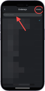 Captura de tela da interface de edição de endereço em um aplicativo móvel exibido em português. No topo da tela aparece o título "Endereço", seguido por um campo de texto com o marcador "Insira o cep", destacado por uma seta vermelha apontando para ele. No canto superior direito, há um botão "Pronto", indicando a opção de confirmar a entrada. À direita da tela, uma marca de seleção azul sinaliza que uma informação foi validada ou aceita. O fundo da imagem está parcialmente pixelado, ocultando detalhes adicionais. A imagem representa o processo de preenchimento ou atualização de dados de localização em uma plataforma digital.